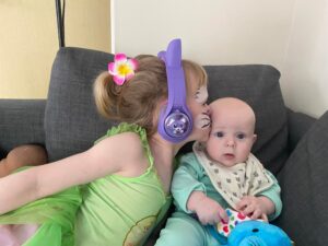 Julias daughter kissing her younger brother on the head